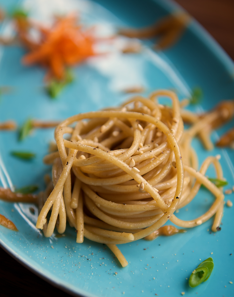swirled spaghetti pasta on blue plate in soft window light by Bret Doss Commercial Food & Product Photography  Seattle