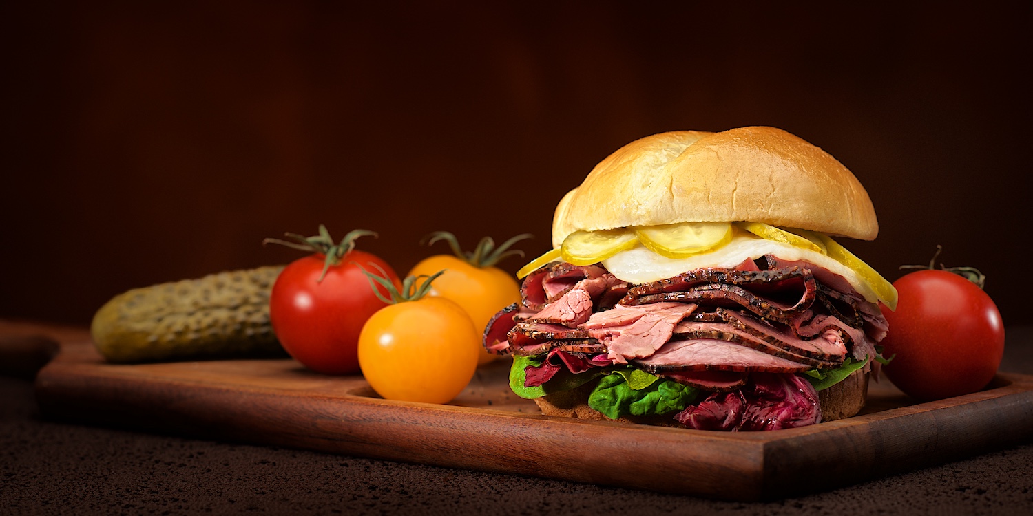 Pastrami & swiss cheese sandwich kaiser roll with pickles tomato